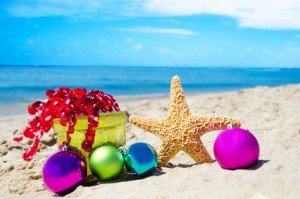 Starfish with gift box and christmas balls on the beach by the ocean - holiday concept